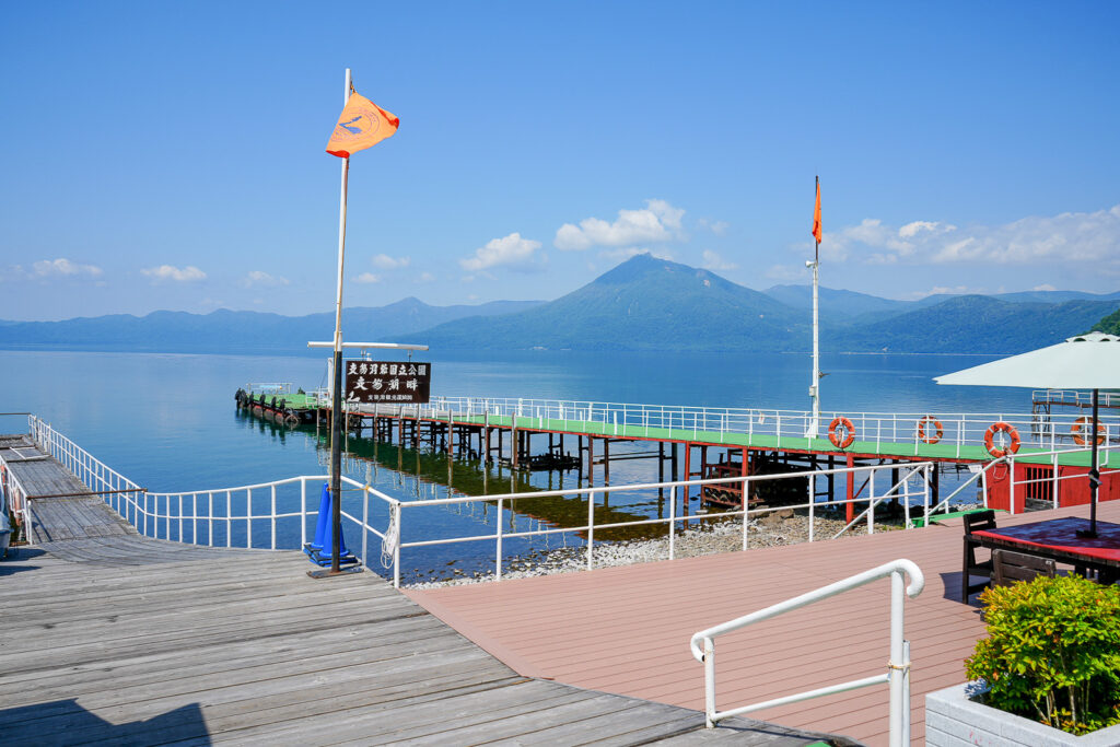 支笏湖の青い湖面と桟橋と山並み