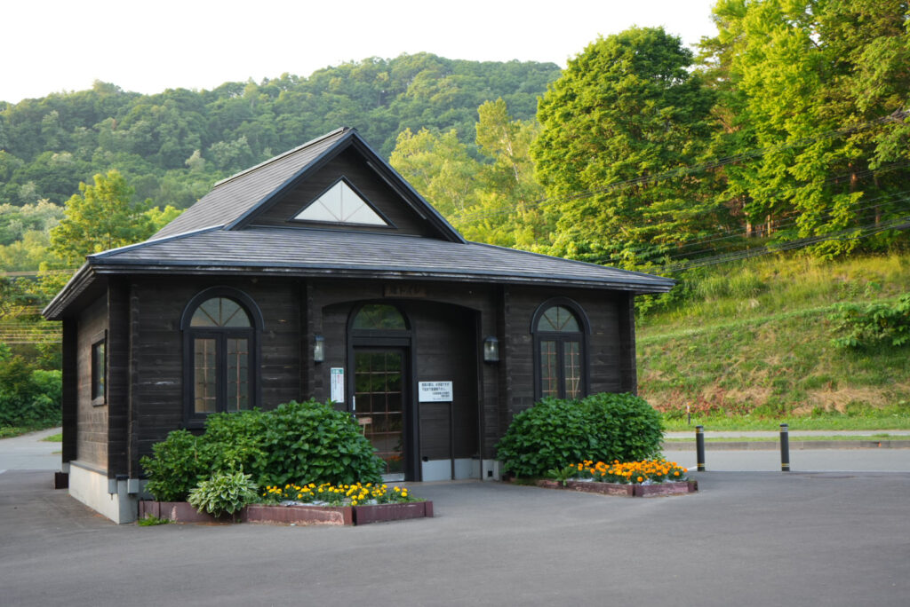 渚公園の洋館風トイレ建物と緑の木々