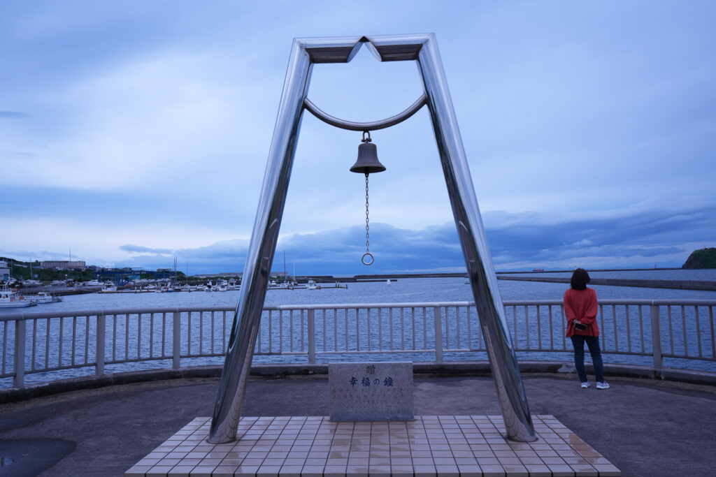 幸福の鐘のモニュメントと背後に広がる室蘭港の眺め