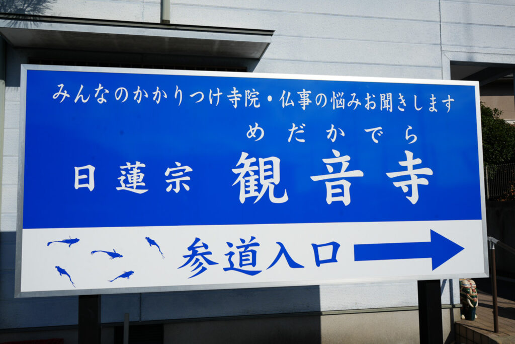 日蓮宗観音寺めだかでらと書かれた参道入口の看板
