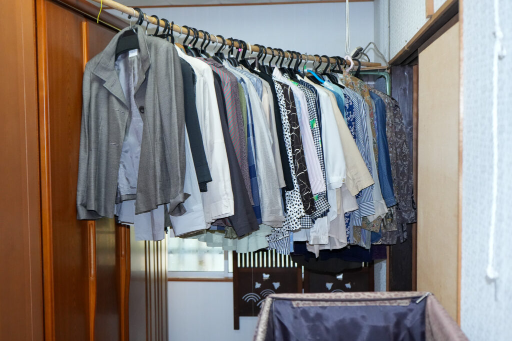 クローゼットから出したスーツや洋服が並んだ状態