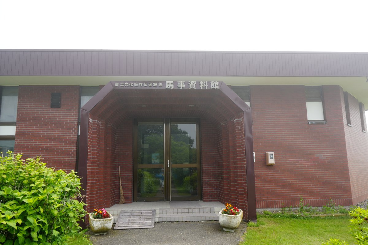 馬事資料館の正面入口。赤レンガ造りの建物に「馬事資料館」の看板が掲げられている。