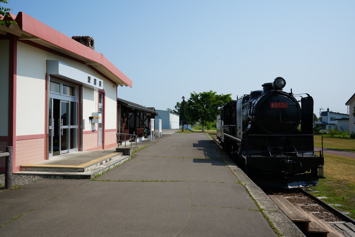 北海道旧愛国駅の赤白の駅舎と保存された黒いSL蒸気機関車