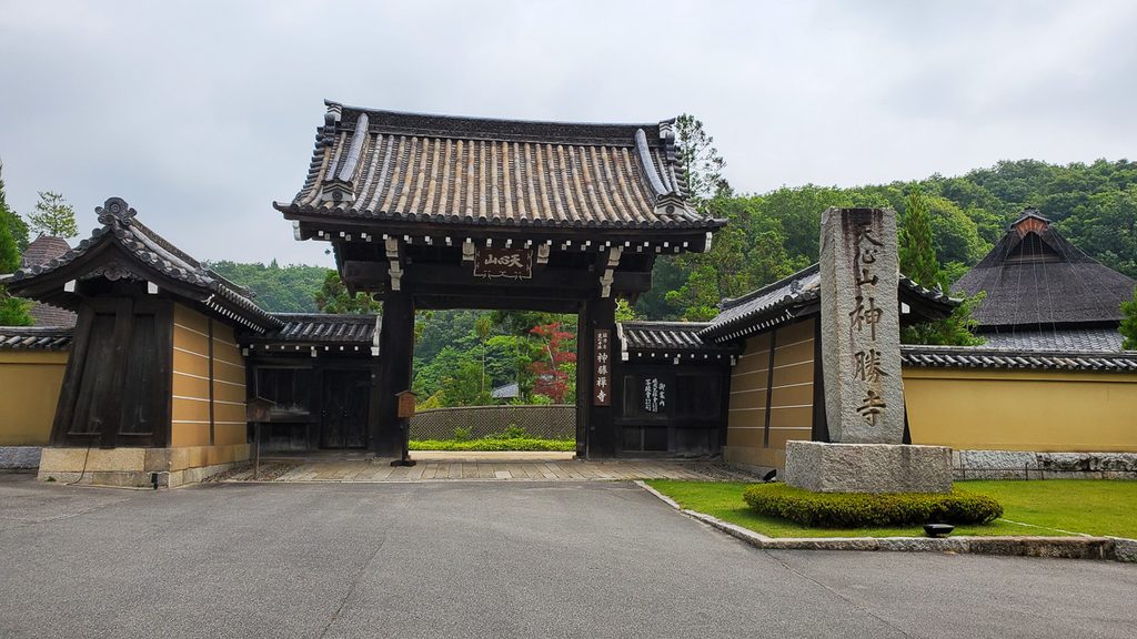 神勝寺の山門と「天心山神勝寺」の石碑。奥には藤森照信さん設計の松堂の屋根も見える。