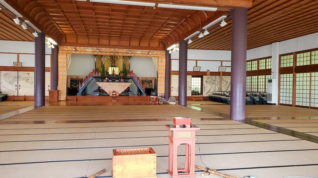 神勝寺の本堂内部。畳敷きの広間の奥に須弥壇と本尊が祀られ、朱塗りの階段や柱が並ぶ。